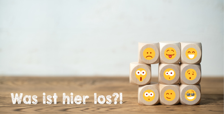 There are cubes stacked on top of each other with different smiley faces. In addition, the sentence "What's going on here?!".