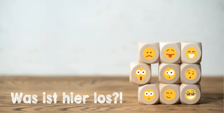 There are cubes stacked on top of each other with different smiley faces. In addition, the sentence "What's going on here?!".